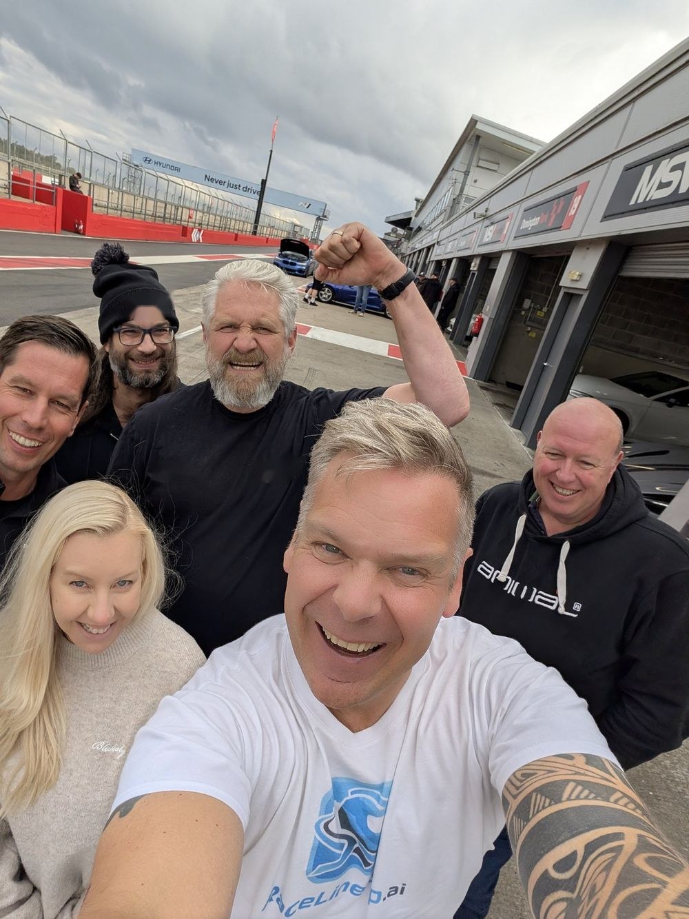 Jonathan Ward takes a selfie in the Donington Park pit lane with Wayne, Jo, Jack, Jim and Paul, the garages and main straight behind them.