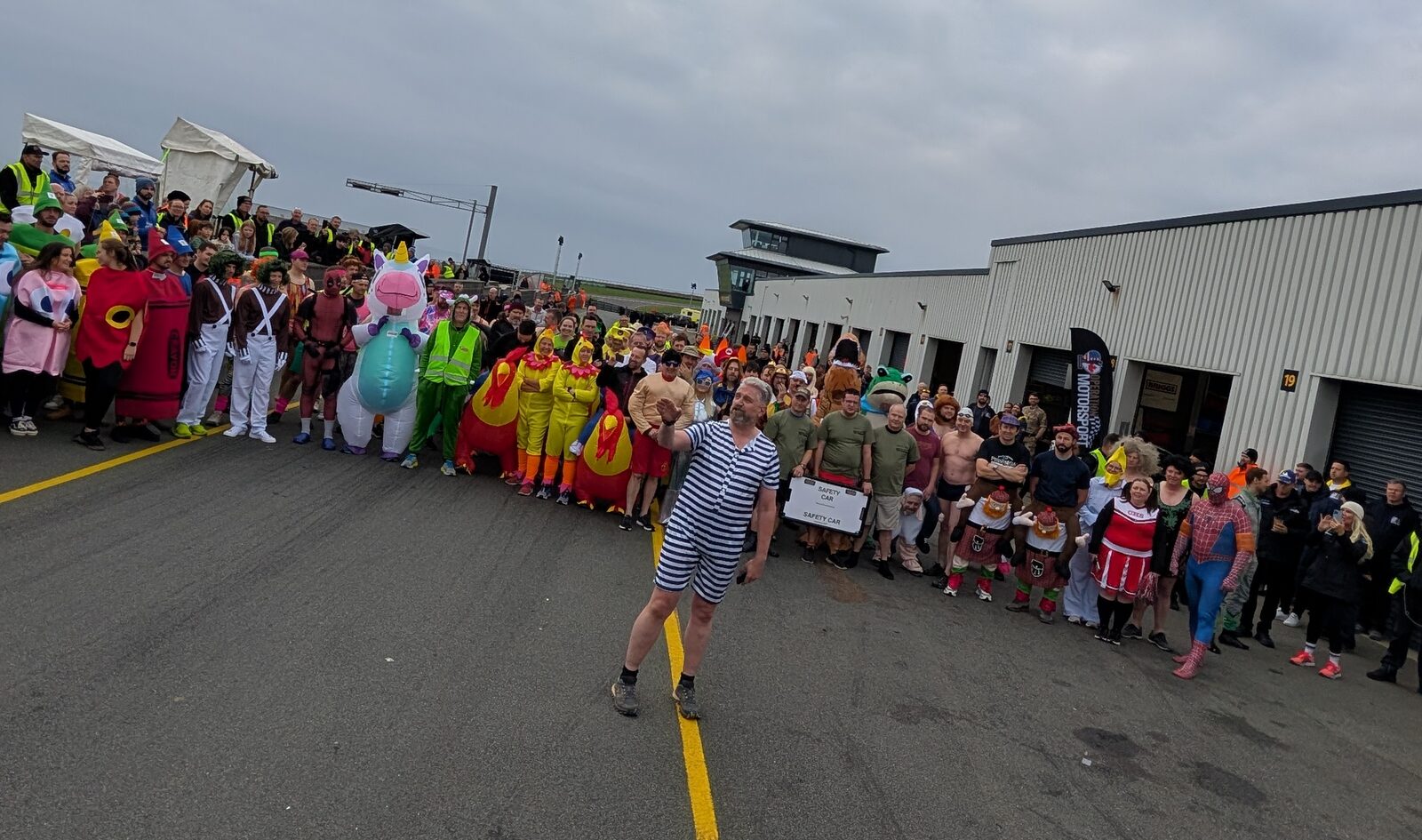 Competitors in fancy dress lining the circuit at Anglesey for the Biathlon of Foolishness.