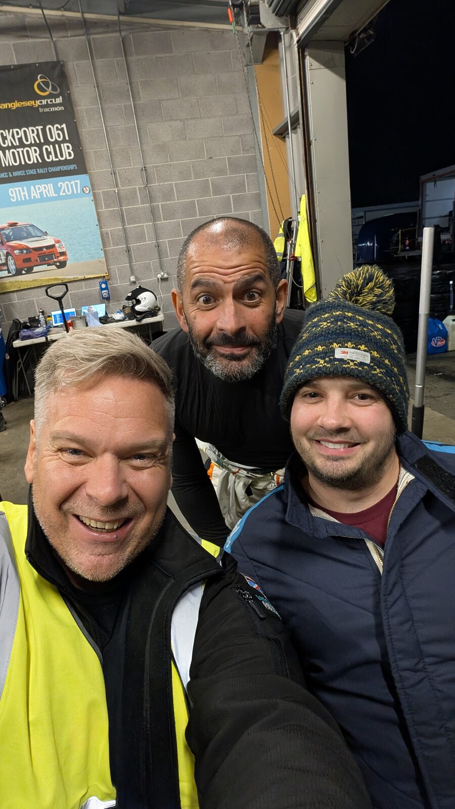 RaceLineApp.ai founder Jon Ward with Chris Harris and a teammate in the garages at Anglesey Circuit.